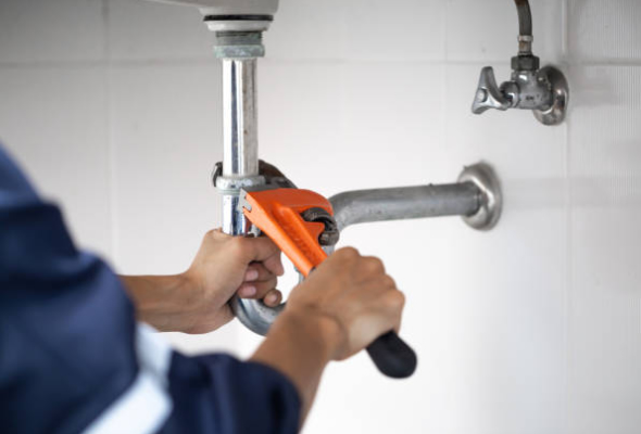 plumber hands adjusting a pipe with a wrench